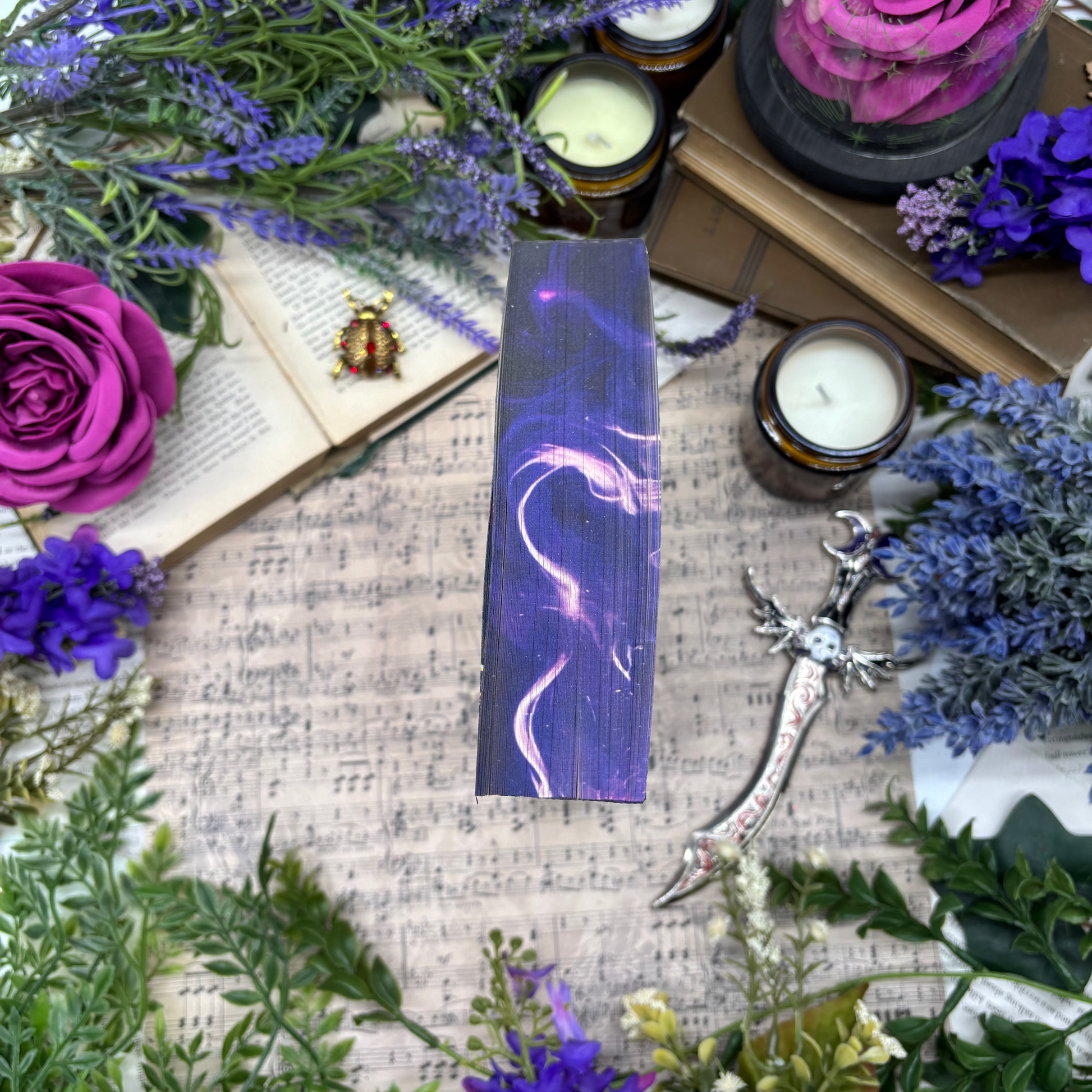 Top of Enchantra special edition paperback by Kaylie Smith with candles and smoke edge design
