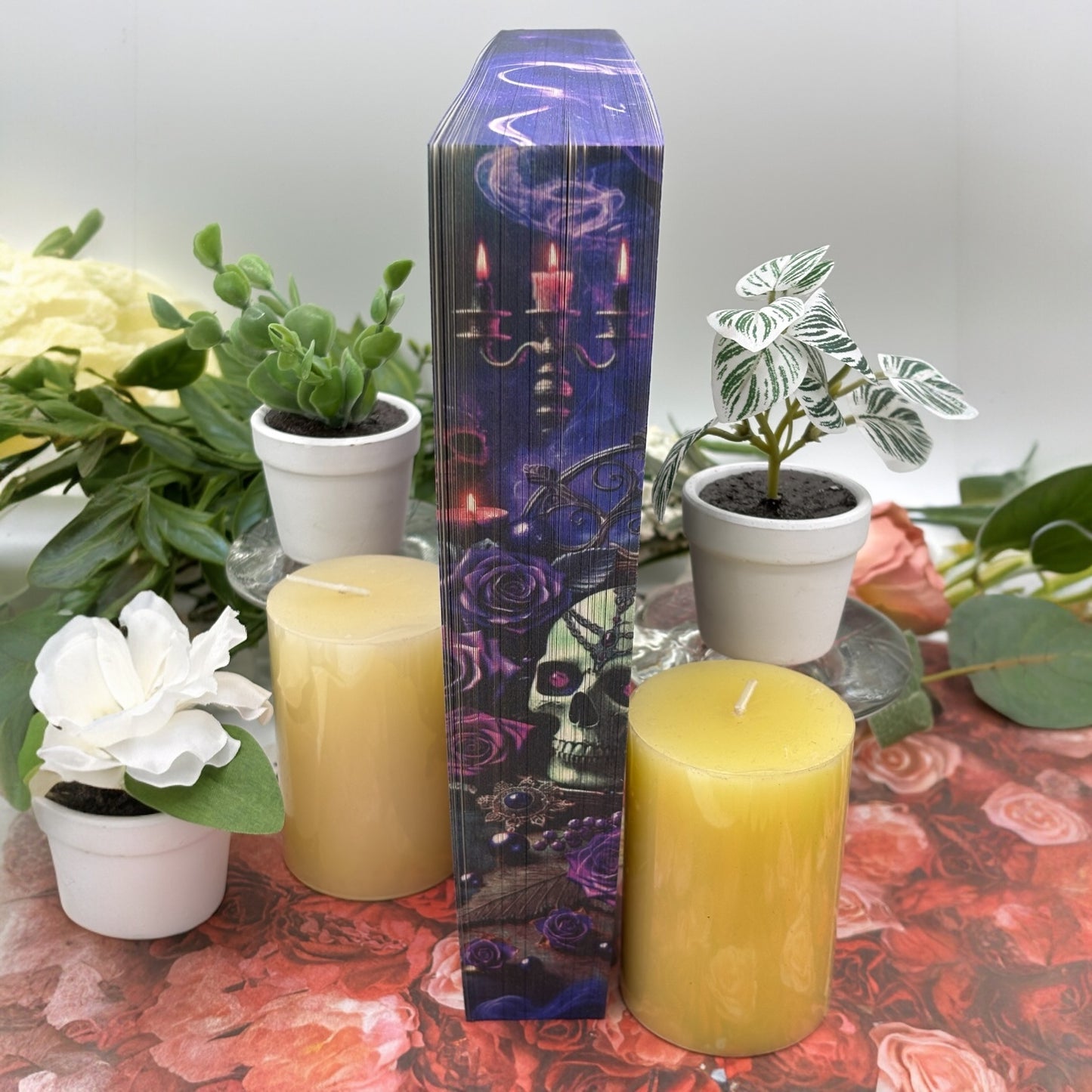 Top, middle of Enchantra special edition paperback by Kaylie Smith with candles and skulls edge design