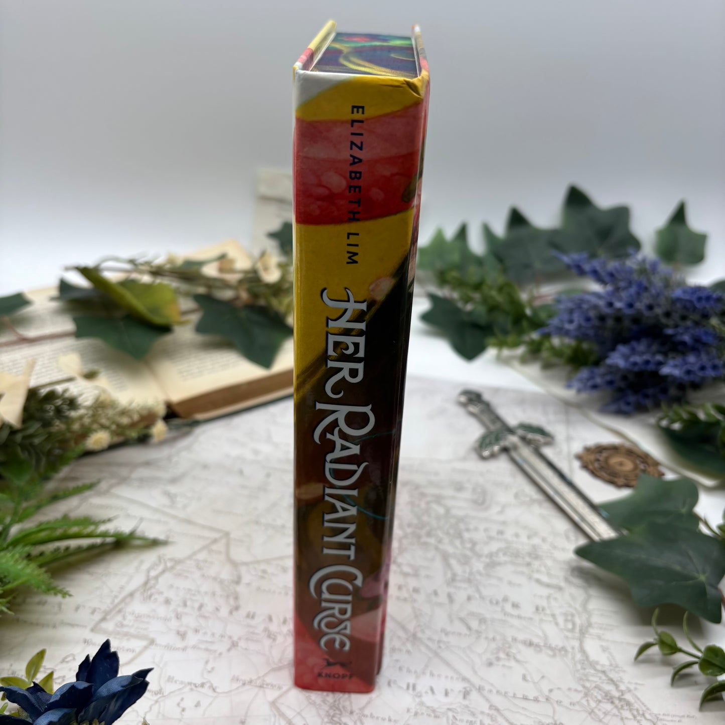 Special edition hardcover of Her Radiant Curse by Elizabeth Lim with stenciled edges