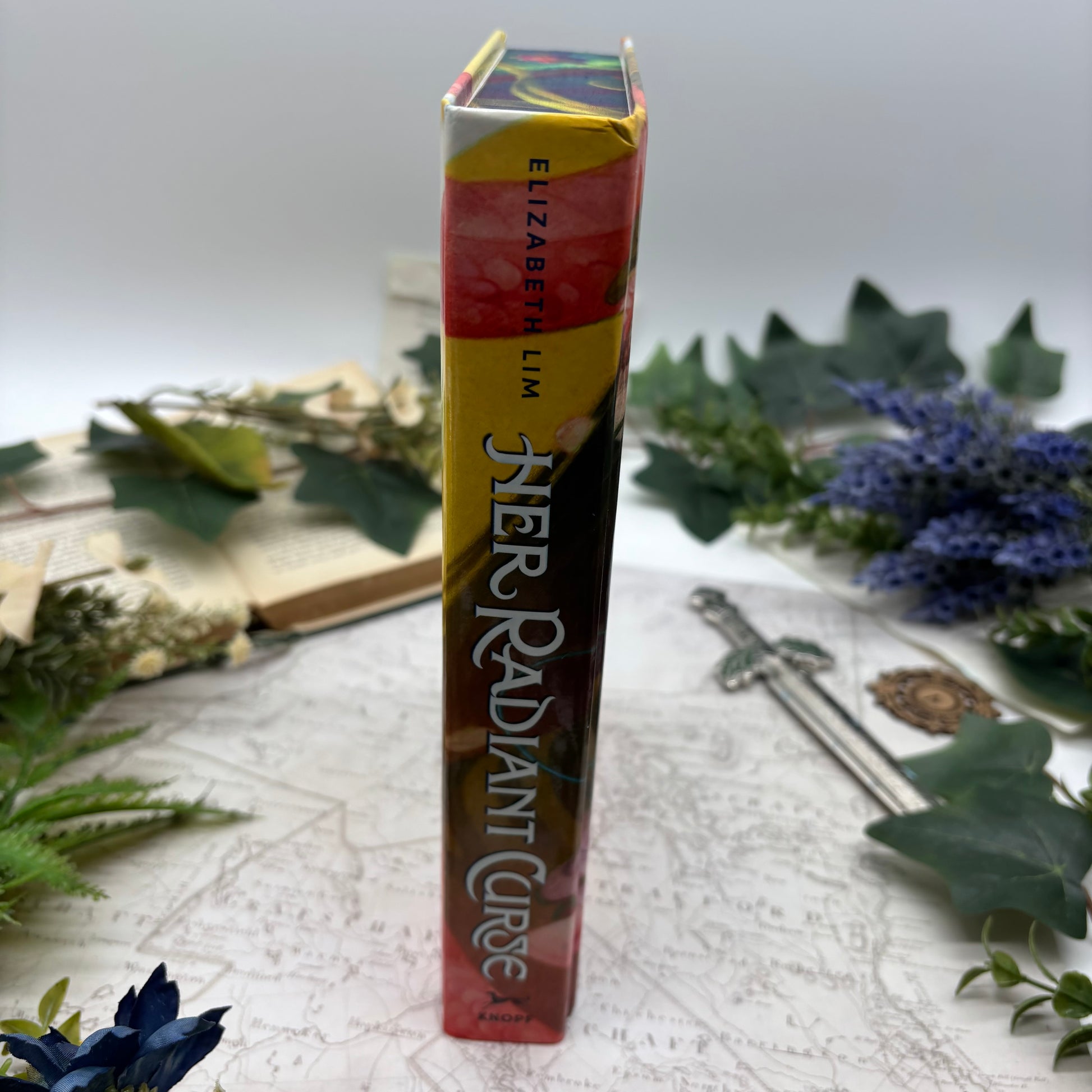 Special edition hardcover of Her Radiant Curse by Elizabeth Lim with stenciled edges