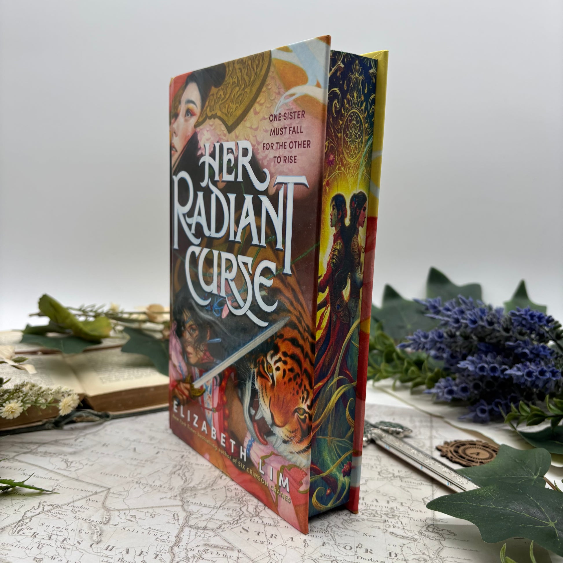 Special edition hardcover of Her Radiant Curse by Elizabeth Lim with stenciled edges